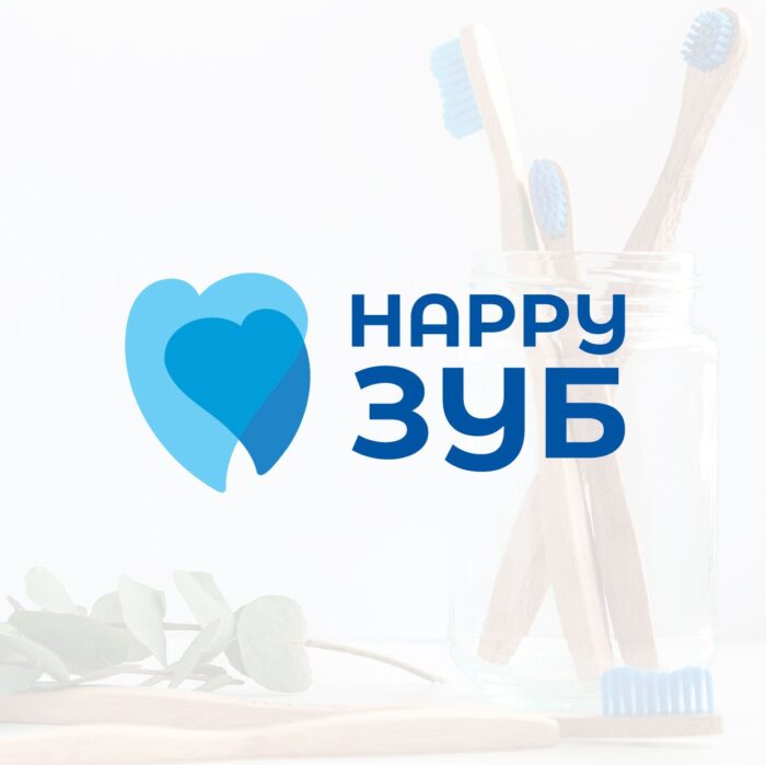 Зображення має логотип з написом “HAPPY ЗУБ”. Перше слово “HAPPY” написано англійською мовою, а друге слово “ЗУБ” - кирилицею. Зліва від тексту є стилізовані сині серця у формі зуба. На фоні видно слабкі контури того, що схоже на перехрещені зубні щітки